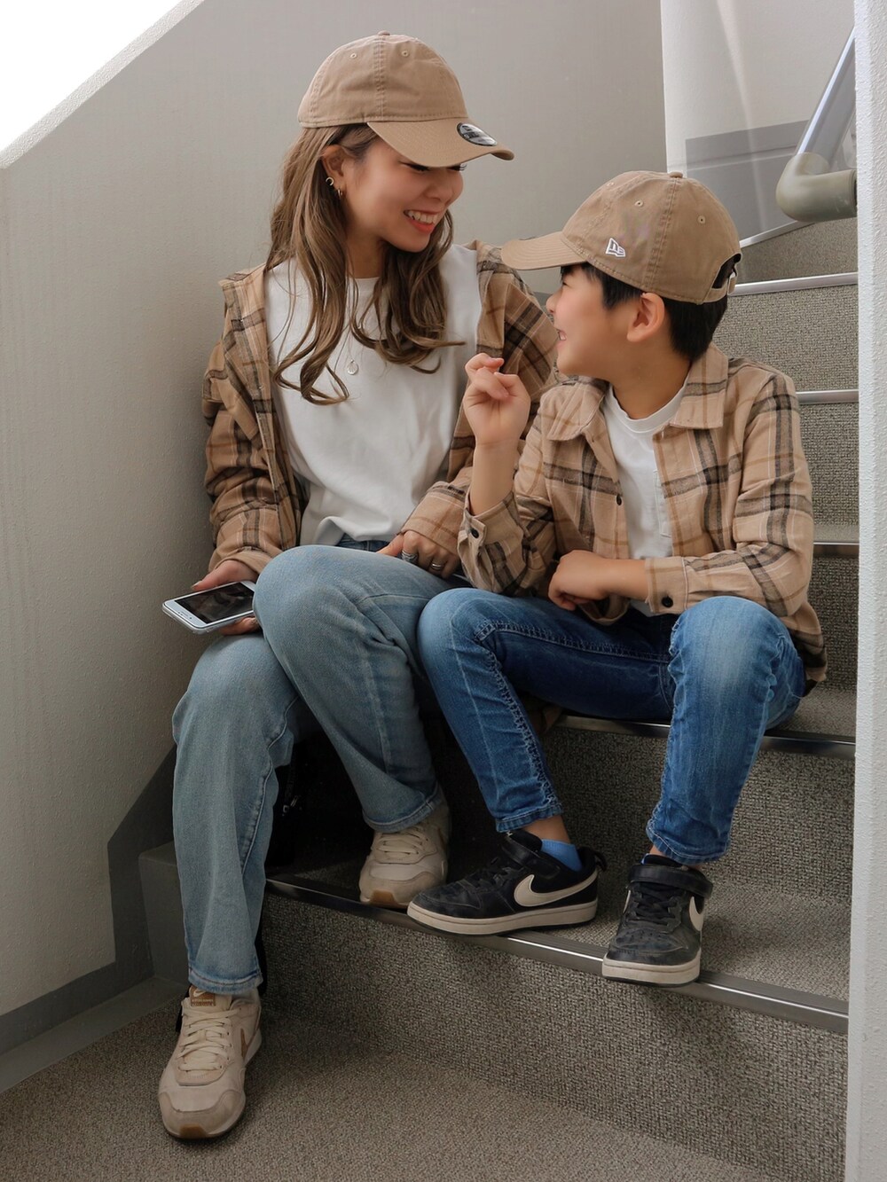 ブラック系のショルダーバッグ、ベージュ系のスニーカー、ベージュ系のキャップを着用したレディースの春コーディネートの3枚目の写真