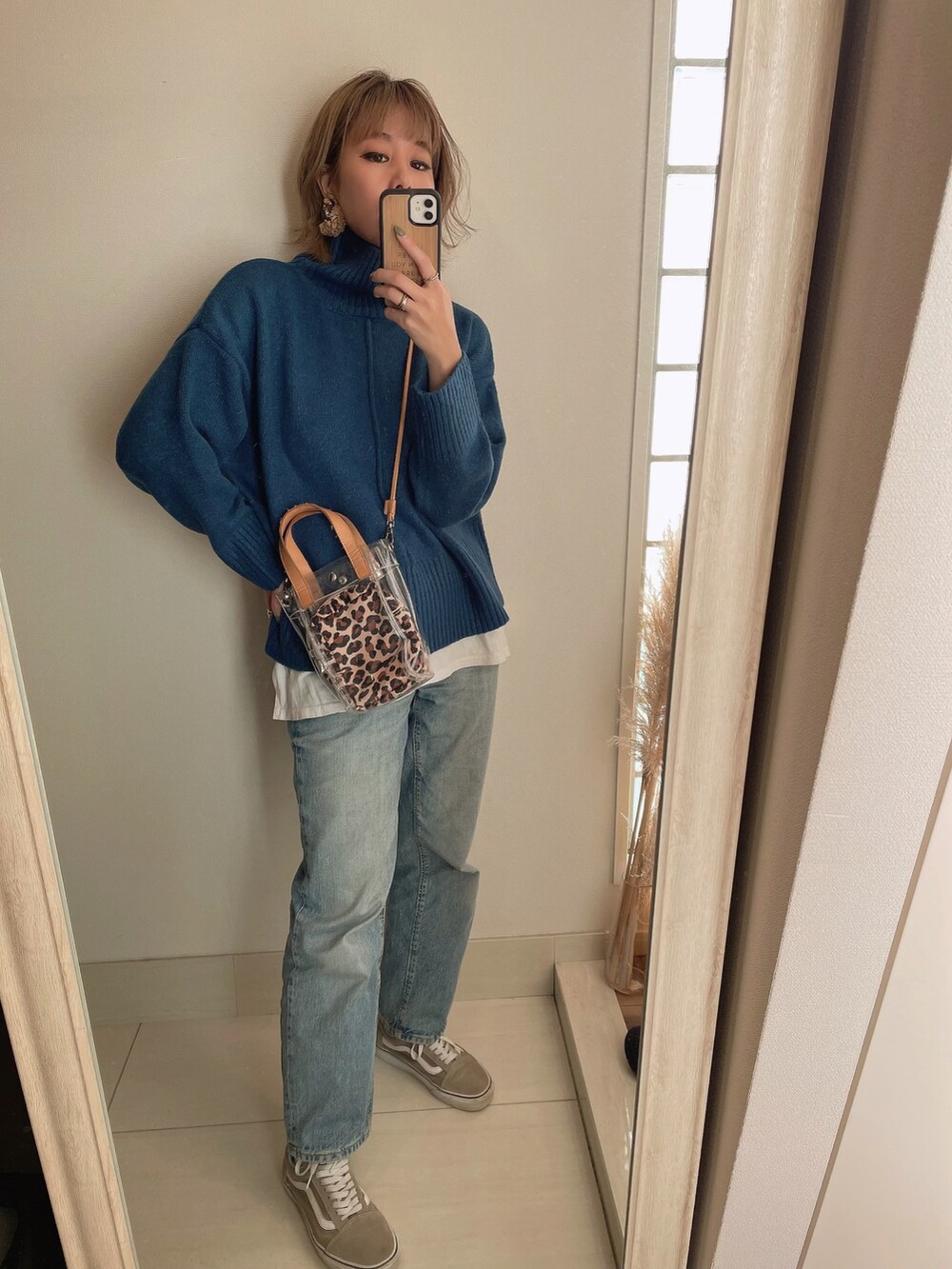 ブルー系のニット/セーター、ベージュ系のショルダーバッグ、ブルー系のデニムパンツを着用したレディースの秋コーディネートの3枚目の写真