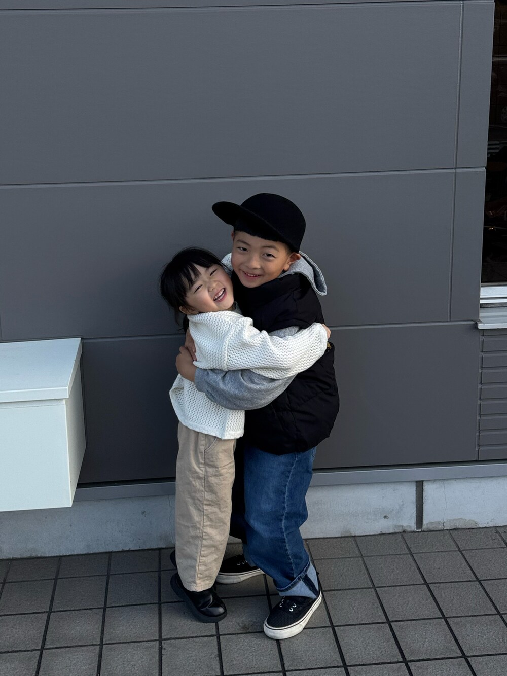 ブラック系のベスト、ブルー系のデニムパンツ、ブラック系のキャップを着用したキッズの冬コーディネートの3枚目の写真