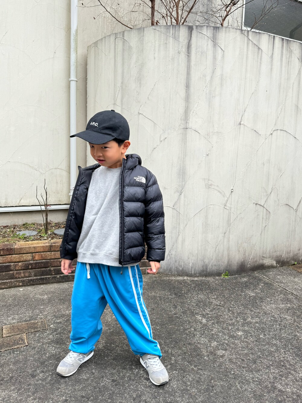 ブラック系のダウンジャケット/コート、ブルー系のその他パンツ、グレー系のスニーカーを着用したキッズの冬コーディネートの3枚目の写真