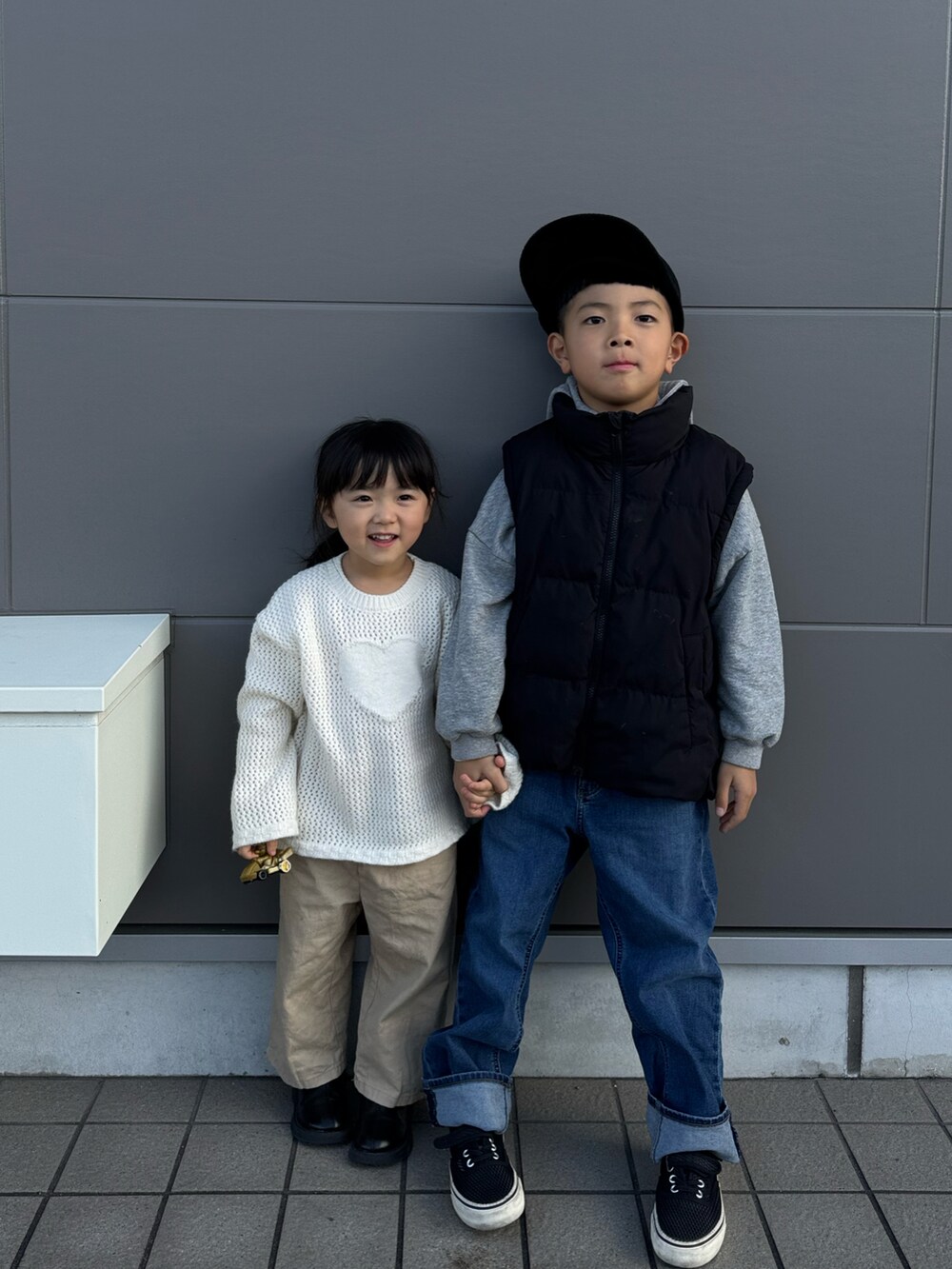 ブラック系のベスト、ブルー系のデニムパンツ、ブラック系のキャップを着用したキッズの冬コーディネートの2枚目の写真