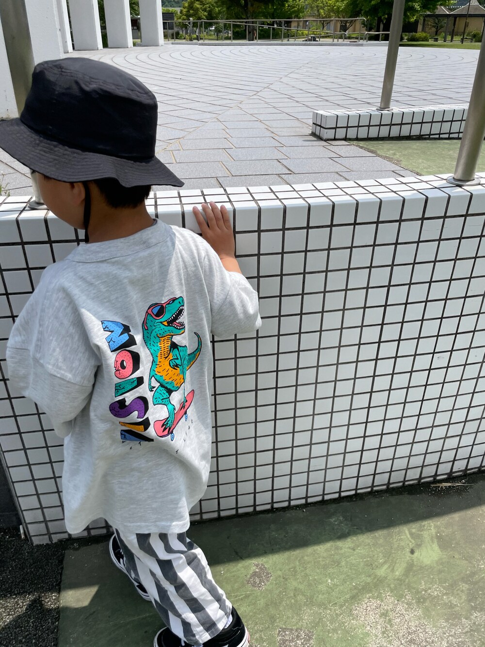 グレー系のTシャツ/カットソー、ホワイト系のパンツ、ブラック系のハットを着用したキッズの春コーディネートの2枚目の写真