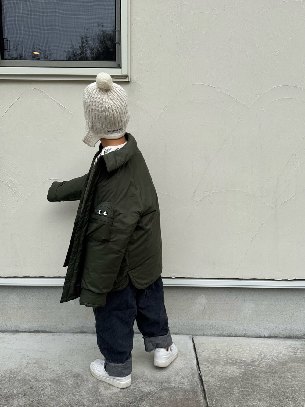 グリーン系のジャケット/アウター、ベージュ系のトップス、ブラック系のデニムパンツを着用したキッズの冬コーディネートの5枚目の写真