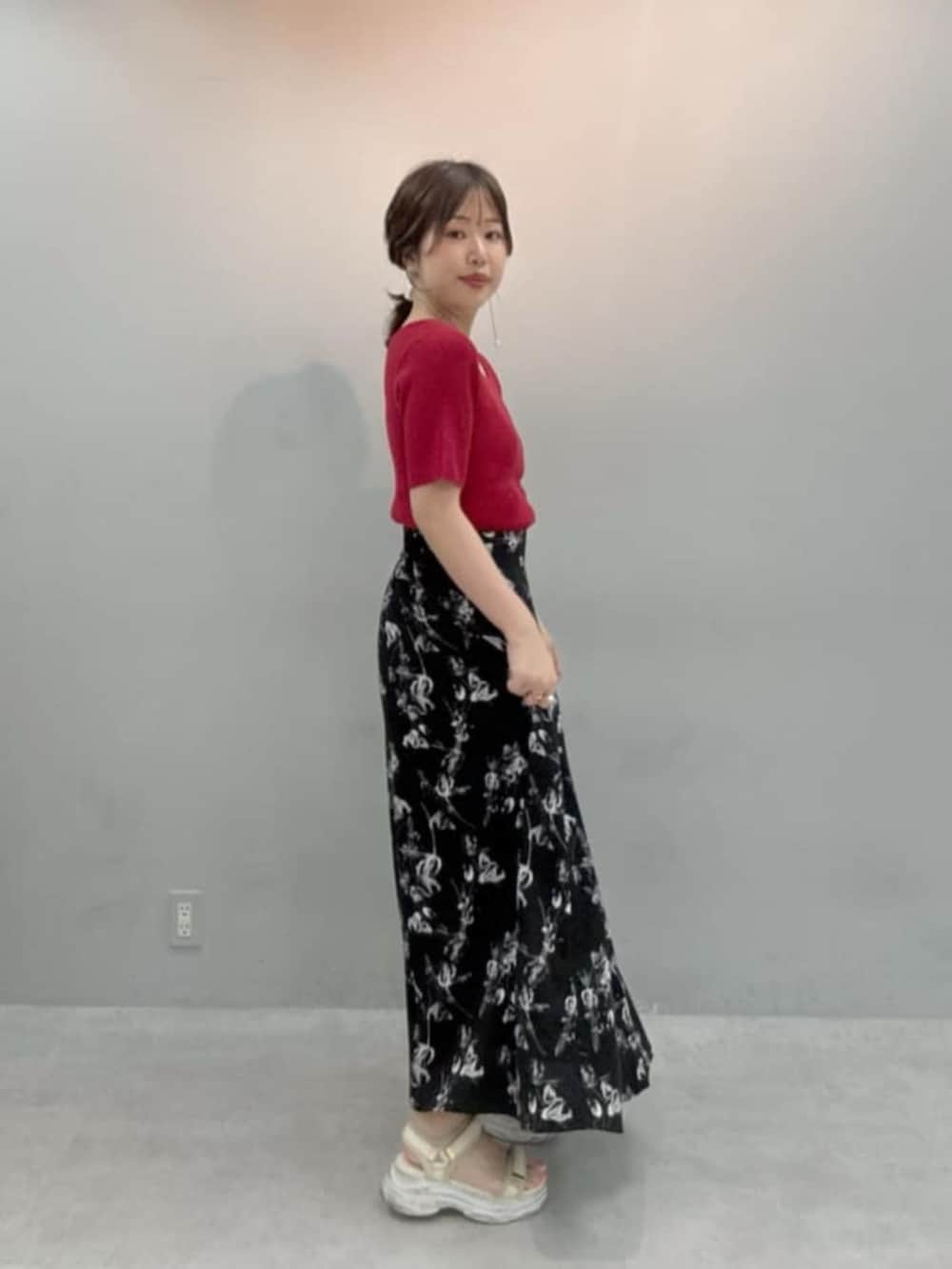 レッド系のニット/セーター、ブラック系のスカートを着用したレディースの夏コーディネートの3枚目の写真