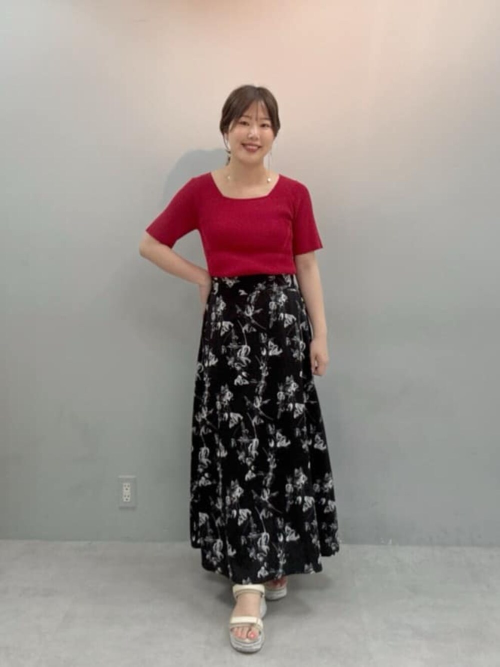 レッド系のニット/セーター、ブラック系のスカートを着用したレディースの夏コーディネートの4枚目の写真