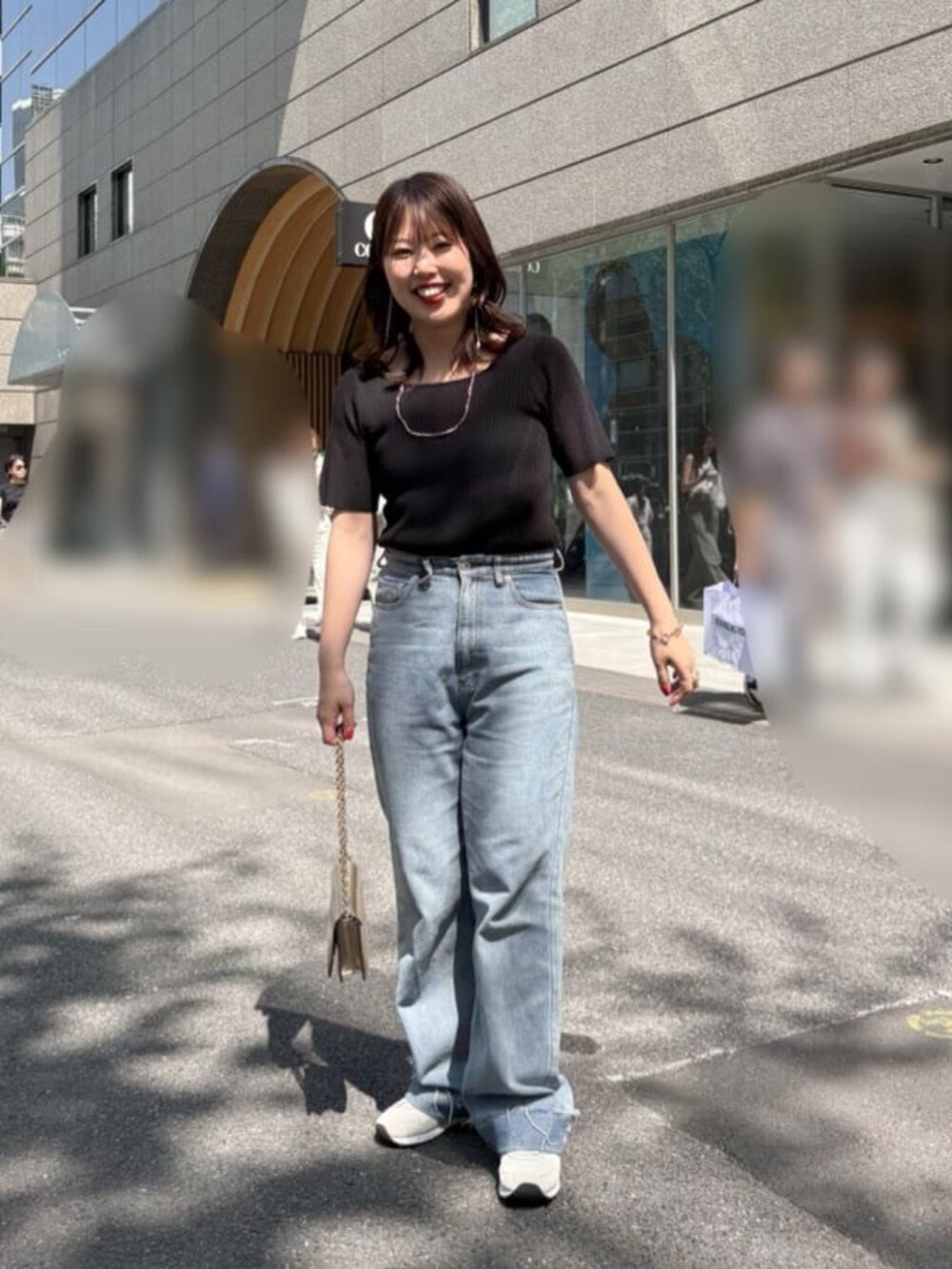 ブルー系のデニムパンツ、ブラック系のニット/セーターを着用したレディースの夏コーディネートの2枚目の写真