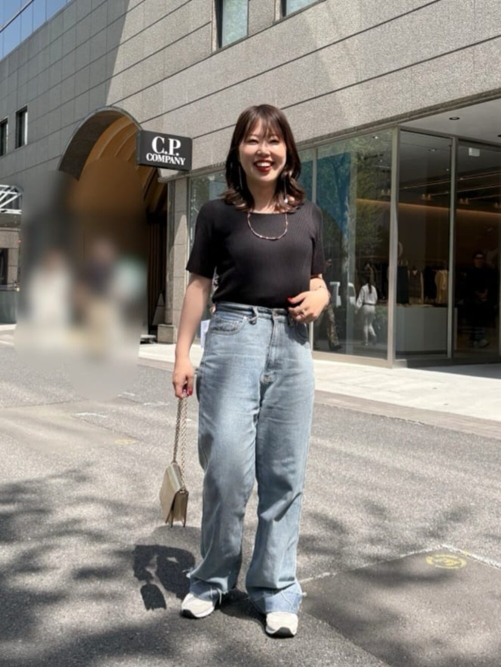 ブルー系のデニムパンツ、ブラック系のニット/セーターを着用したレディースの夏コーディネートの3枚目の写真