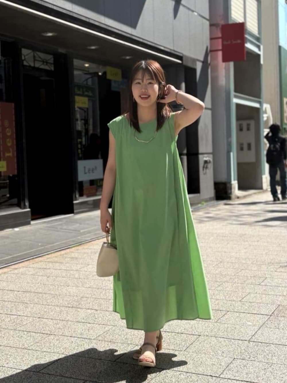 グリーン系のワンピースを着用したレディースの夏コーディネートの2枚目の写真