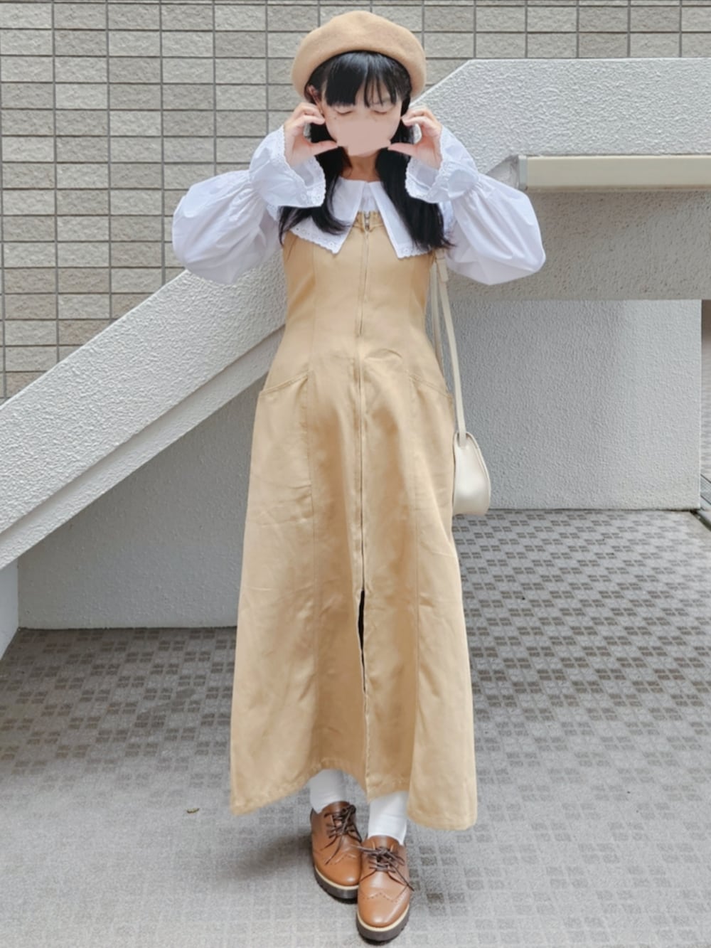 ベージュ系のジャンパースカート、ホワイト系のシャツ/ブラウス、ベージュ系のショルダーバッグを着用したレディースの秋コーディネートの2枚目の写真