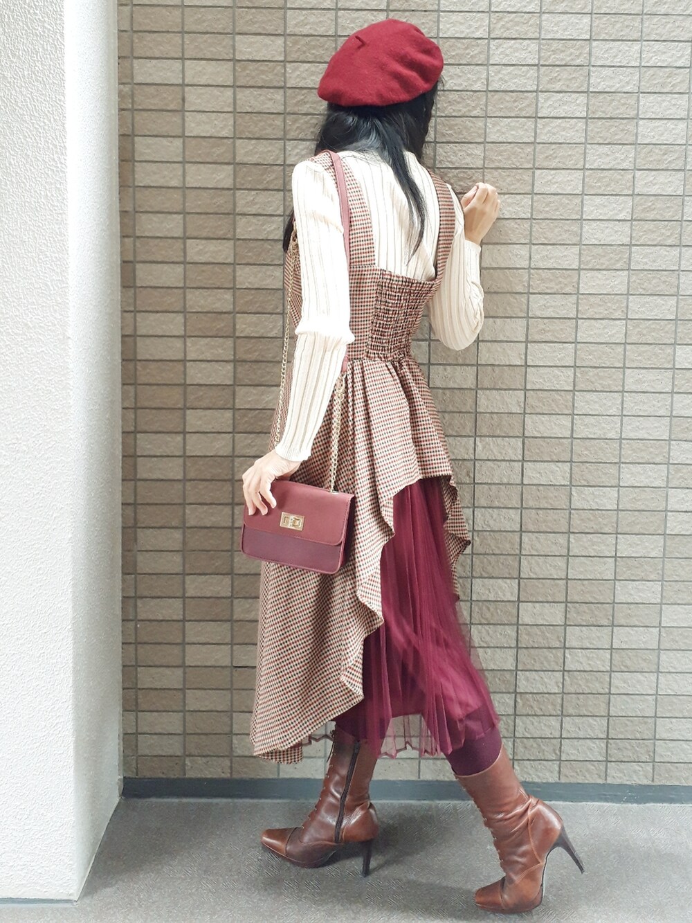 ホワイト系のトレンチコート、ブラウン系のジャンパースカート、レッド系のショルダーバッグを着用したレディースの秋コーディネートの4枚目の写真