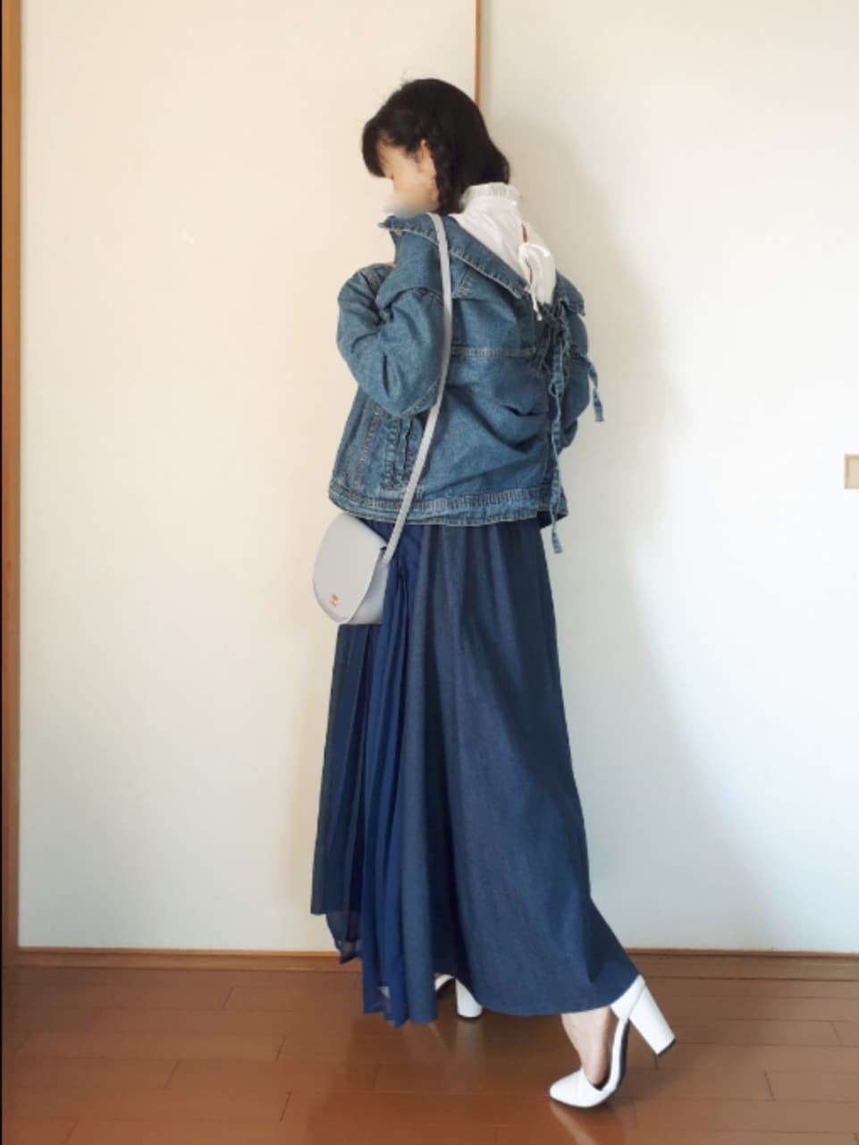 ブルー系のデニムジャケット、ブルー系のワンピース、ブルー系のショルダーバッグを着用したレディースの春コーディネートの2枚目の写真