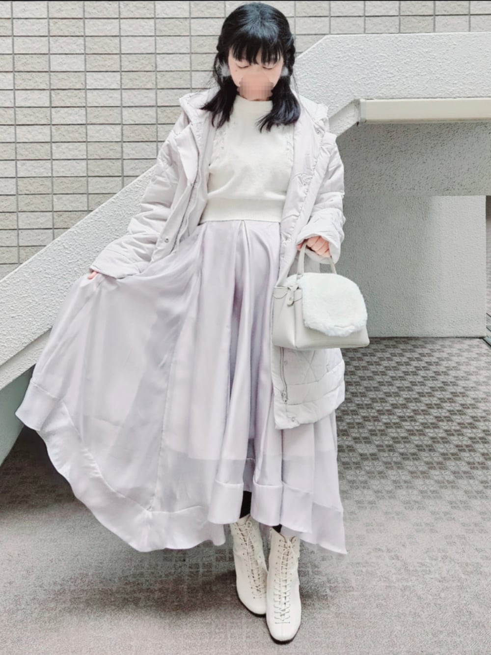ホワイト系のジャケット/アウター、ベージュ系のスカート、ホワイト系のニット/セーターを着用したレディースの冬コーディネートの3枚目の写真