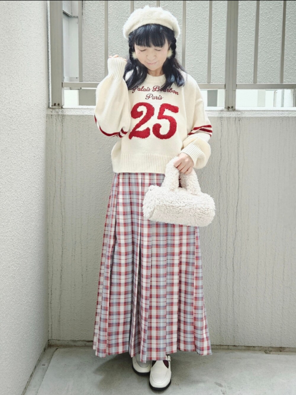 レッド系のピーコート、ホワイト系のニット/セーター、レッド系のスカートを着用したレディースの冬コーディネートの4枚目の写真