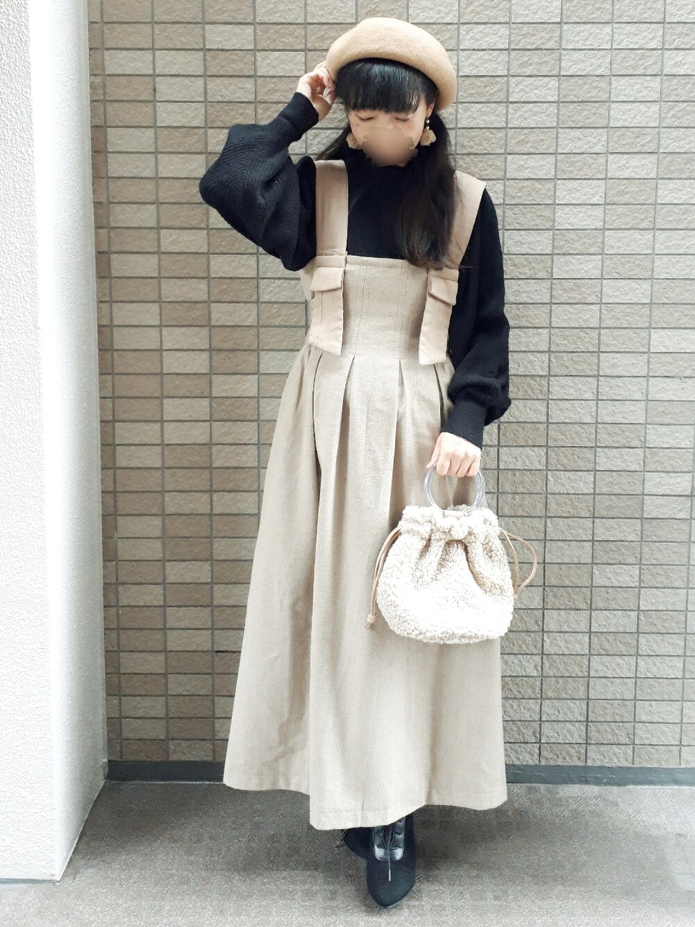 ブラウン系のブルゾン、ブラック系のニット/セーター、ベージュ系のスカートを着用したレディースの冬コーディネートの4枚目の写真