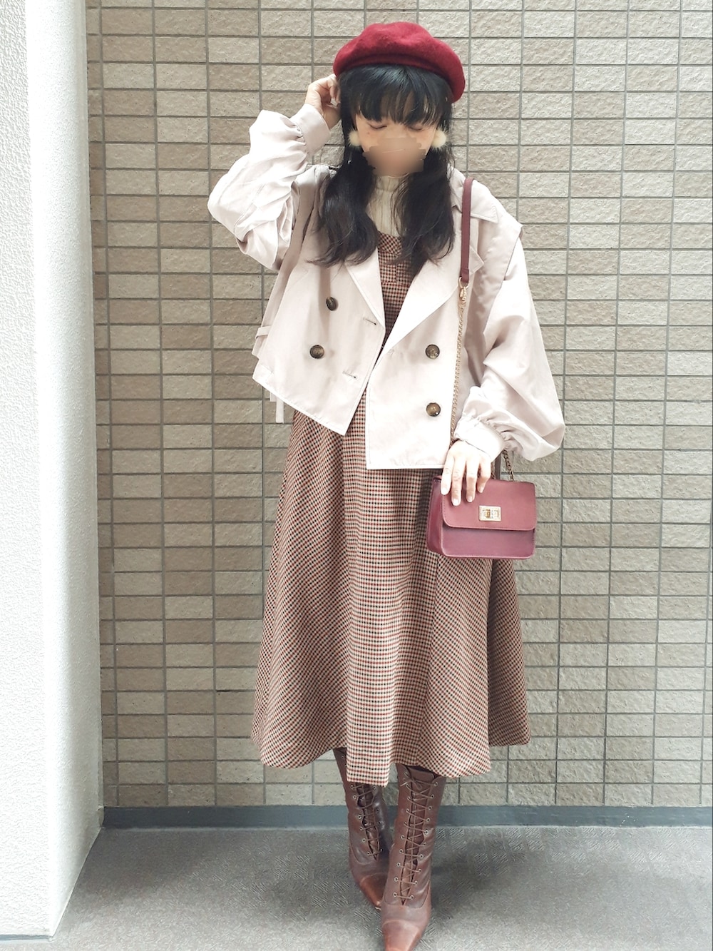 ホワイト系のトレンチコート、ブラウン系のジャンパースカート、レッド系のショルダーバッグを着用したレディースの秋コーディネートの2枚目の写真
