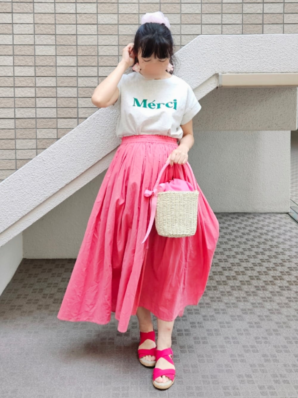 ピンク系のかごバッグ、ホワイト系のTシャツ/カットソー、ピンク系のサンダルを着用したレディースの夏コーディネートの3枚目の写真