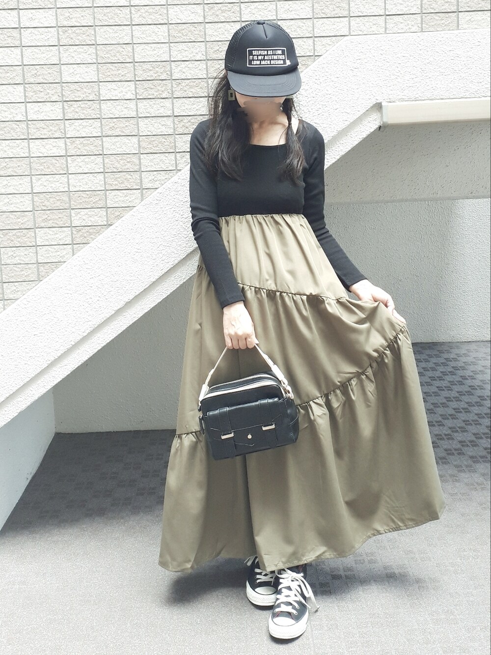 ブラック系のデニムジャケット、ブラック系のワンピース、ブラック系のショルダーバッグを着用したレディースの秋コーディネートの4枚目の写真
