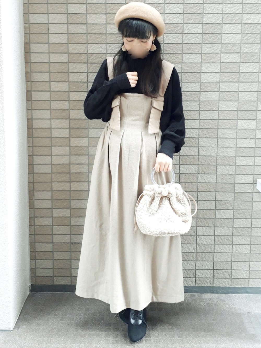 ブラウン系のブルゾン、ブラック系のニット/セーター、ベージュ系のスカートを着用したレディースの冬コーディネートの3枚目の写真
