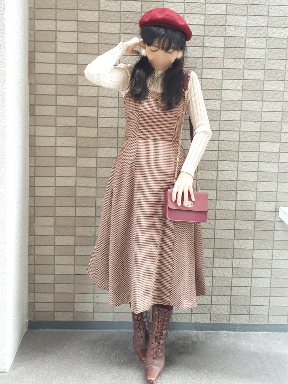 ホワイト系のトレンチコート、ブラウン系のジャンパースカート、レッド系のショルダーバッグを着用したレディースの秋コーディネートの3枚目の写真