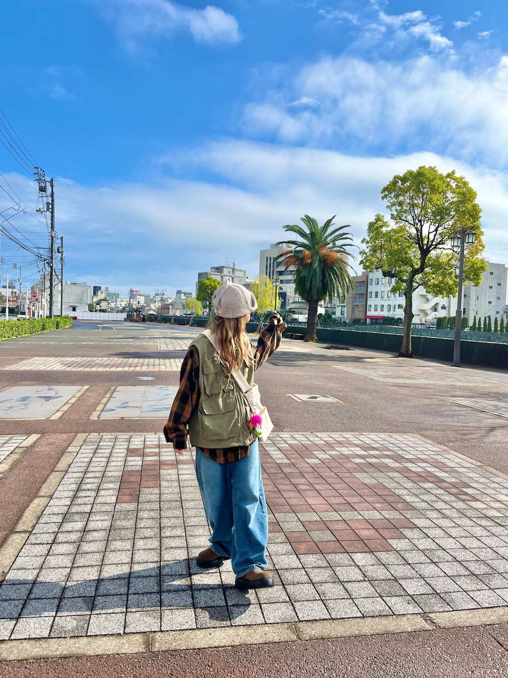 ブルー系のデニムパンツ、ブラウン系のその他シューズ、ベージュ系のニットキャップ/ビーニーを着用したレディースの秋コーディネートの2枚目の写真