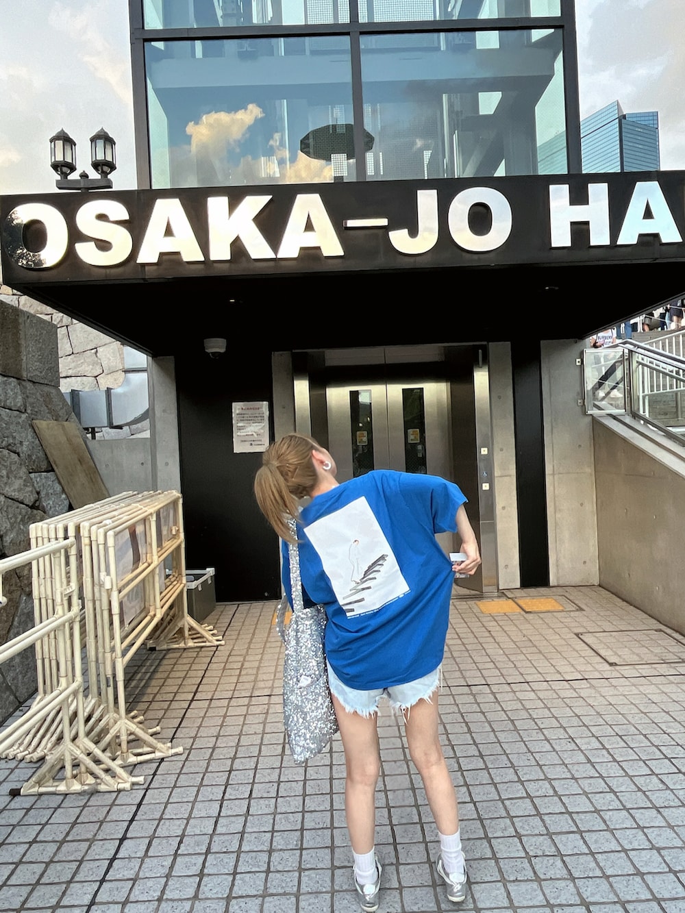 シルバー系のトートバッグ、シルバー系のスニーカーを着用したレディースの秋コーディネートの2枚目の写真