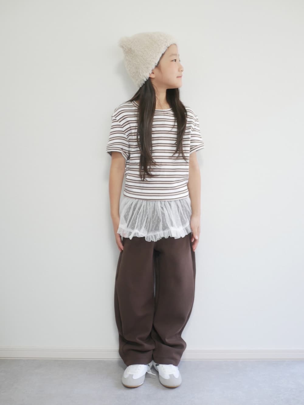ブラウン系のTシャツ/カットソー、ホワイト系のスカート、ブラック系のスウェットパンツを着用したキッズの秋コーディネートの3枚目の写真