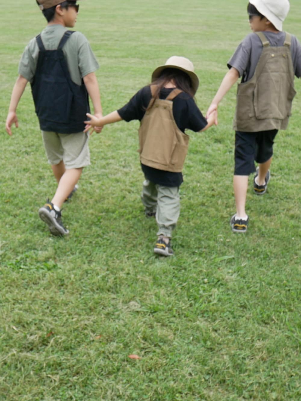 ブラック系のベスト、グリーン系のベスト、ベージュ系のベストを着用したキッズの夏コーディネートの2枚目の写真