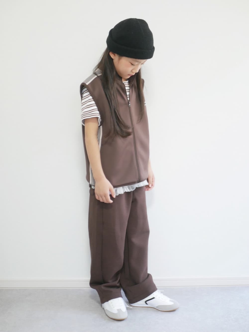 ブラウン系のTシャツ/カットソー、ホワイト系のスカート、ブラック系のスウェットパンツを着用したキッズの秋コーディネートの2枚目の写真