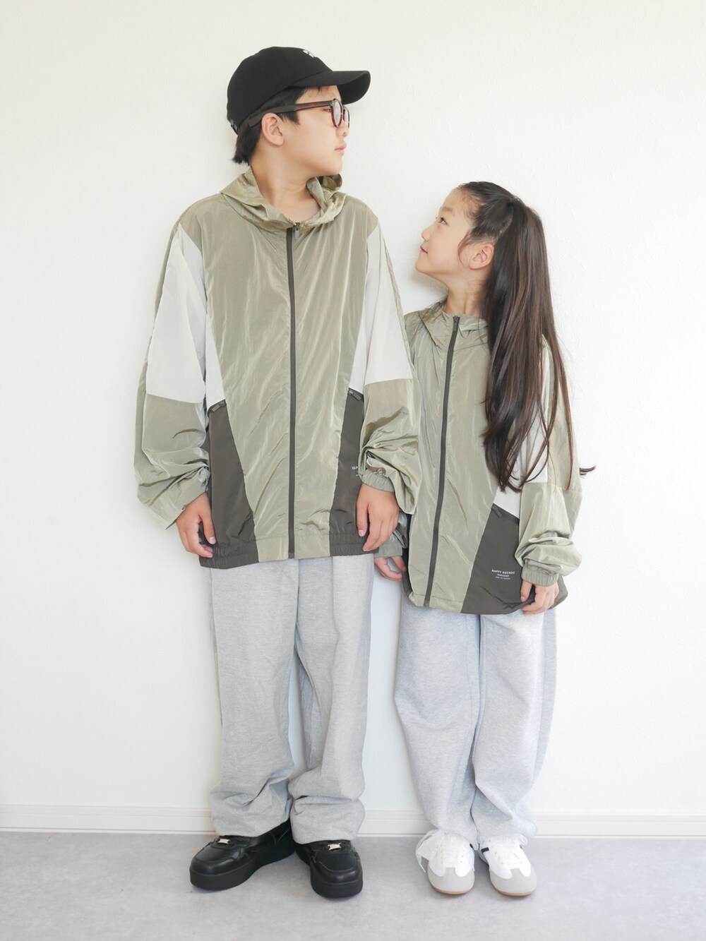 ブルー系のナイロンジャケット、ブラック系のスウェットパンツ、ホワイト系のスニーカーを着用したキッズの秋コーディネートの4枚目の写真