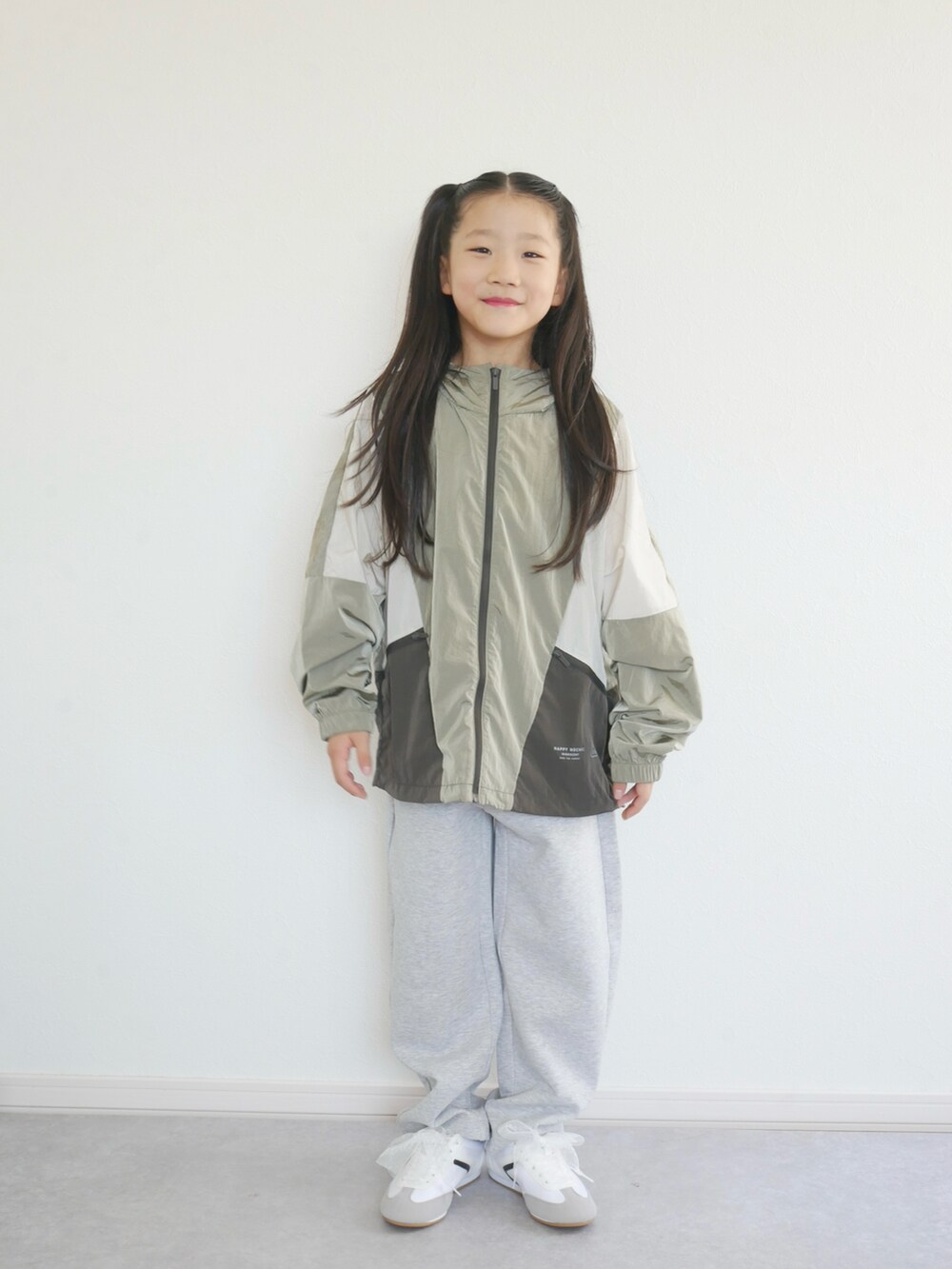 ブルー系のナイロンジャケット、ブラック系のスウェットパンツ、ホワイト系のスニーカーを着用したキッズの秋コーディネートの3枚目の写真