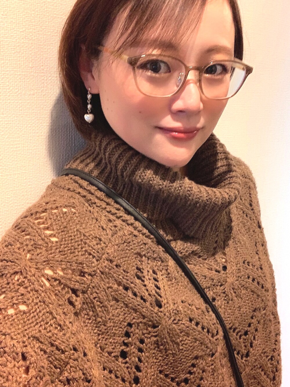 ブラウン系のニット/セーター、ブラック系のショルダーバッグ、グリーン系のスカートを着用したレディースの冬コーディネートの3枚目の写真