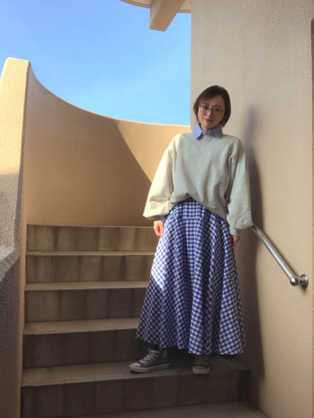 グレー系のスウェット、ブルー系のシャツ/ブラウス、ブルー系のスカートを着用したレディースの春コーディネートの2枚目の写真