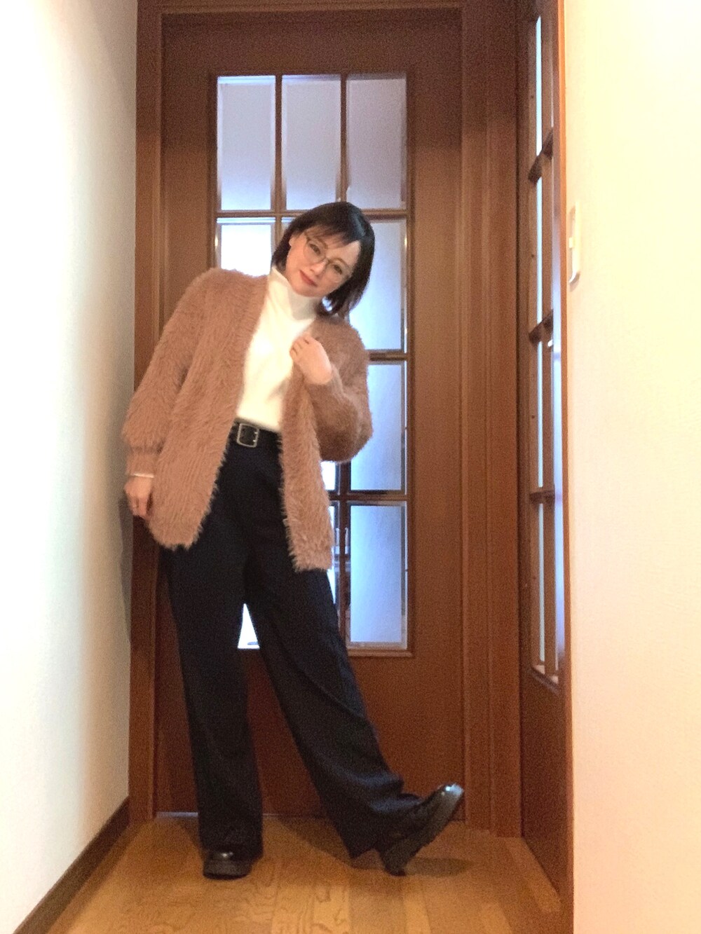 ホワイト系のニット/セーター、ブルー系のスラックス、ブラウン系のカーディガン/ボレロを着用したレディースの冬コーディネートの2枚目の写真