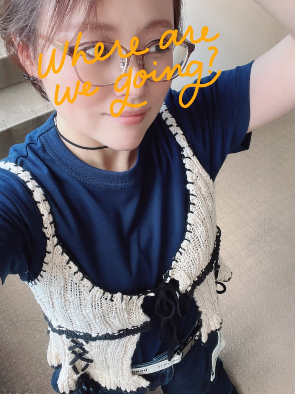 ブルー系のデニムパンツ、ホワイト系のベスト、ブラック系のスニーカーを着用したレディースの秋コーディネートの2枚目の写真