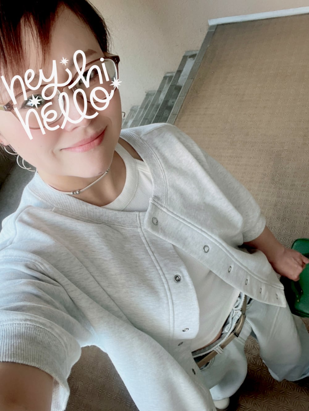 グリーン系のハンドバッグ、ブルー系のデニムパンツ、ベージュ系のブーツを着用したレディースの秋コーディネートの2枚目の写真