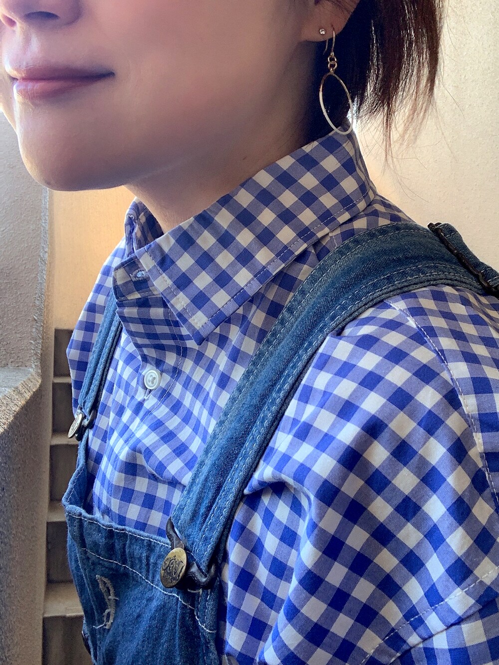 ブルー系のシャツ/ブラウス、ブルー系のサロペット/オーバーオール、ホワイト系のスニーカーを着用したレディースの春コーディネートの2枚目の写真