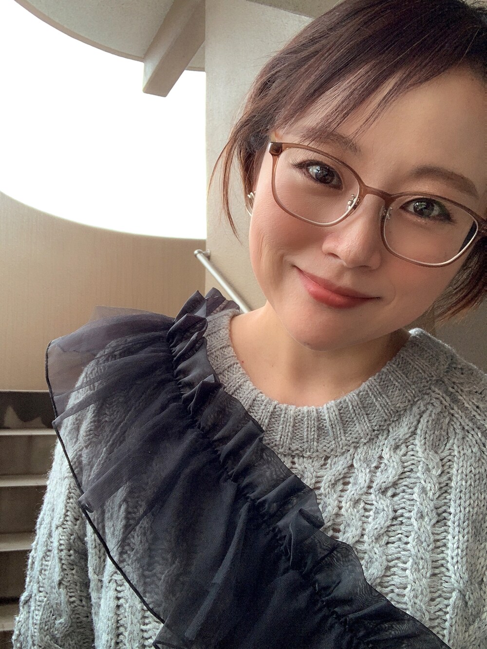 グレー系のワンピース、ブラック系のブーツ、ブラック系の付け襟を着用したレディースの冬コーディネートの3枚目の写真