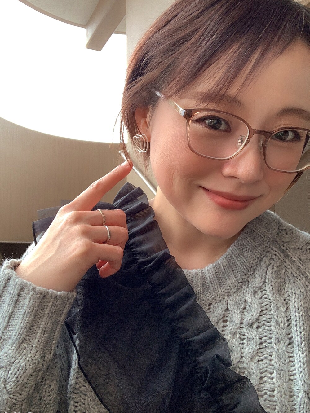 グレー系のワンピース、ブラック系のブーツ、ブラック系の付け襟を着用したレディースの冬コーディネートの4枚目の写真