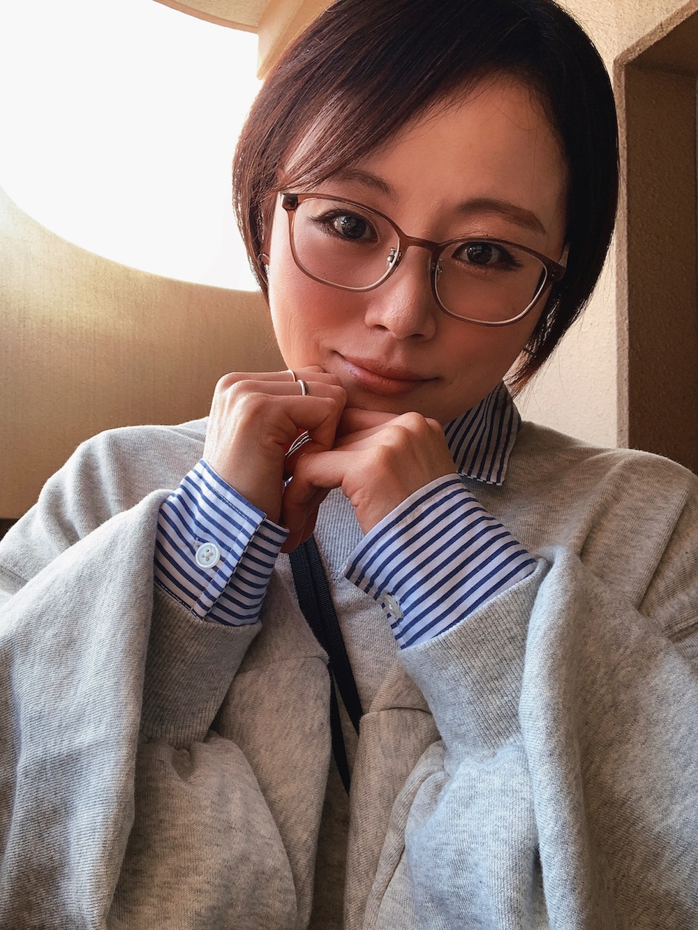 グレー系のスウェット、ブルー系のシャツ/ブラウス、ブルー系のデニムパンツを着用したレディースの冬コーディネートの2枚目の写真