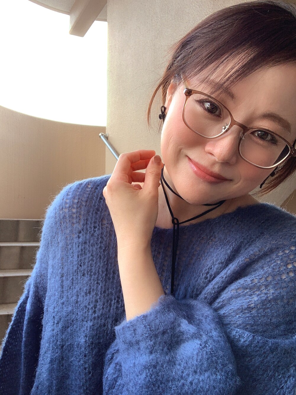 ブルー系のニット/セーター、ブルー系のデニムパンツ、ブラック系のブーツを着用したレディースの冬コーディネートの3枚目の写真