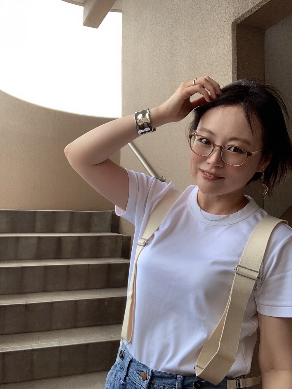 ホワイト系のTシャツ/カットソー、ブルー系のサロペット/オーバーオール、ホワイト系のスニーカーを着用したレディースの夏コーディネートの3枚目の写真