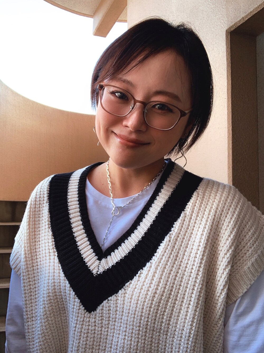 ホワイト系のベスト、ホワイト系のTシャツ/カットソー、ブルー系のデニムパンツを着用したレディースの秋コーディネートの2枚目の写真