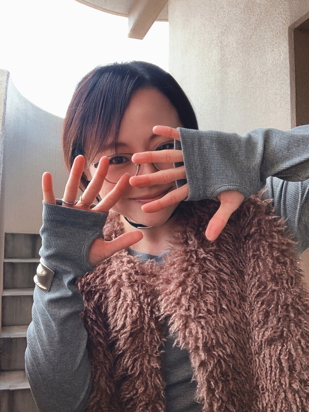 ブラウン系のベスト、グレー系のワンピース、ブラック系のブーツを着用したレディースの冬コーディネートの2枚目の写真