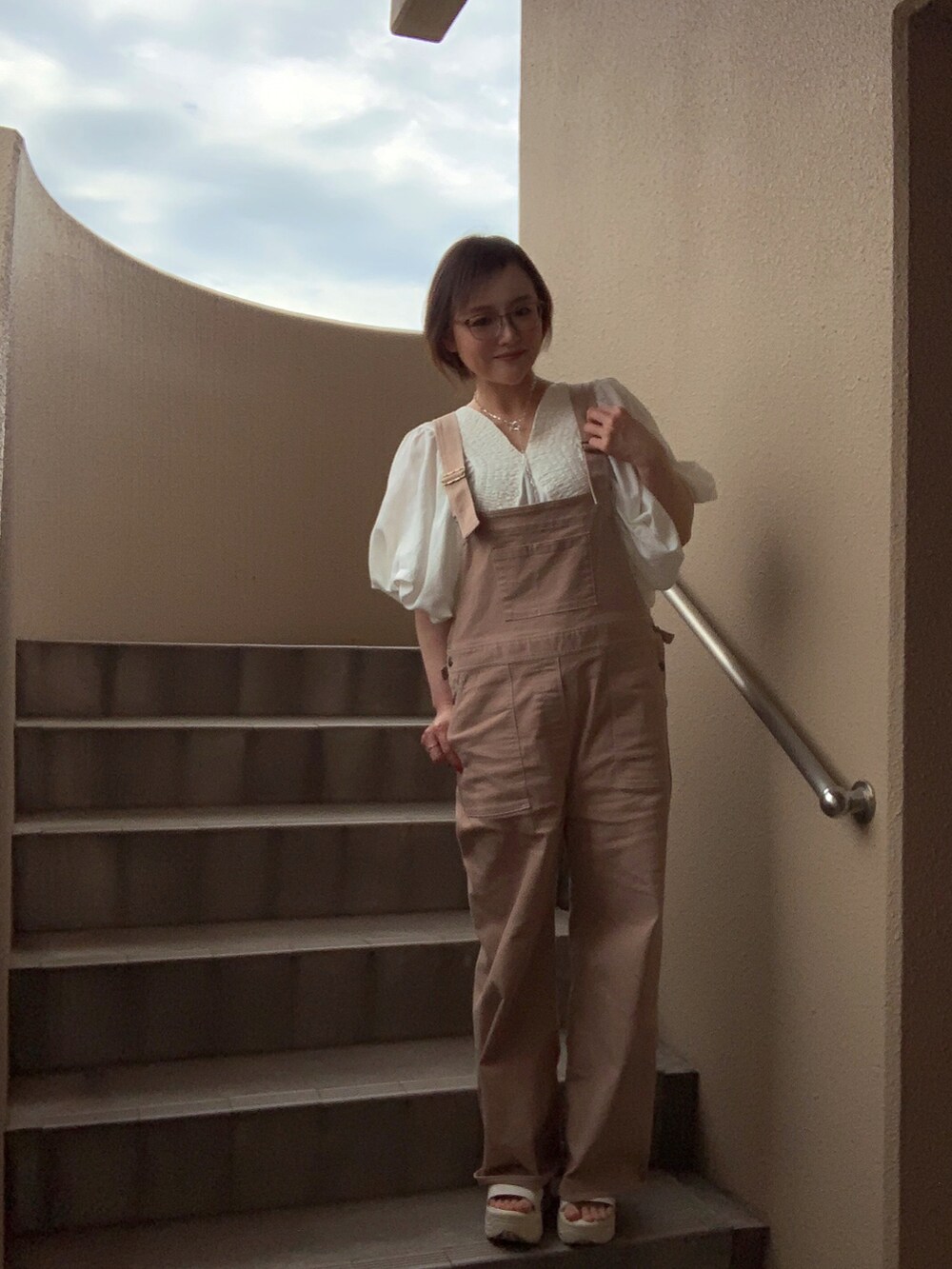 ホワイト系のシャツ/ブラウス、ベージュ系のサロペット/オーバーオール、ホワイト系のサンダルを着用したレディースの春コーディネートの4枚目の写真