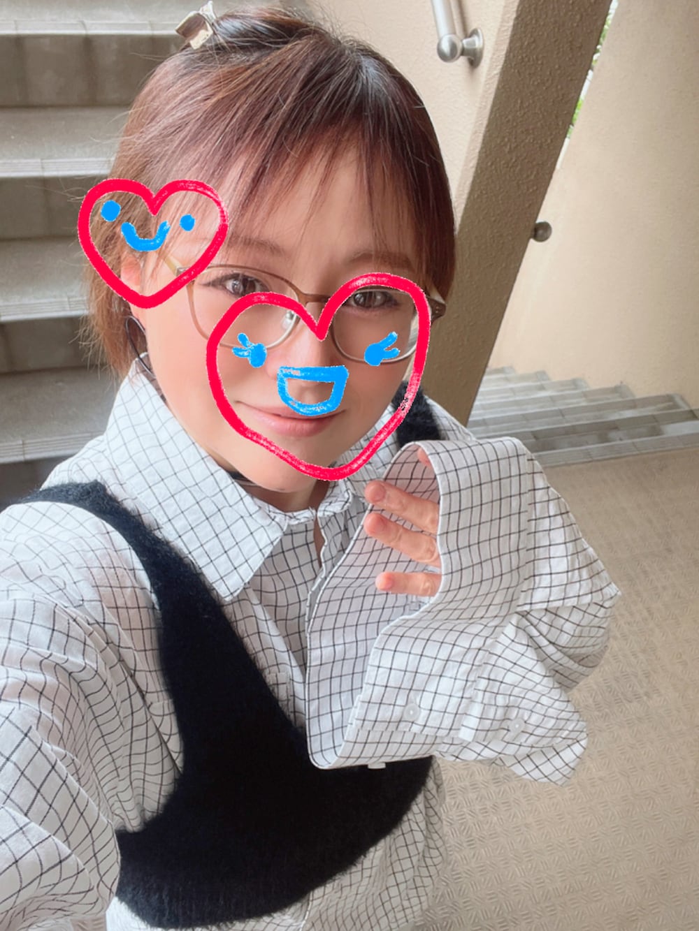 ブラック系のベスト、ホワイト系のシャツ/ブラウス、ブルー系のデニムパンツを着用したレディースの春コーディネートの2枚目の写真