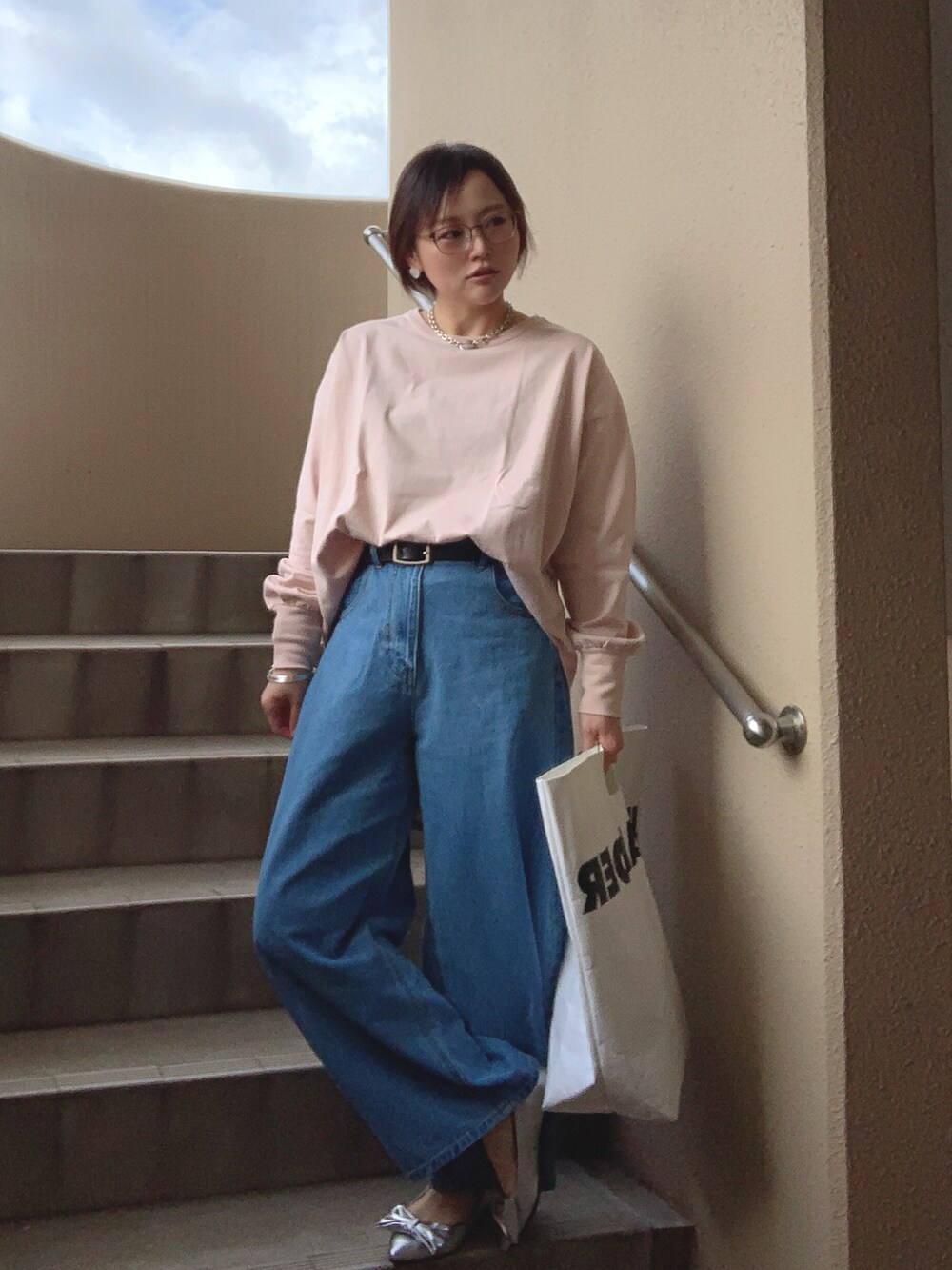 ピンク系のTシャツ/カットソー、ブルー系のデニムパンツ、シルバー系のパンプスを着用したレディースの春コーディネートの3枚目の写真