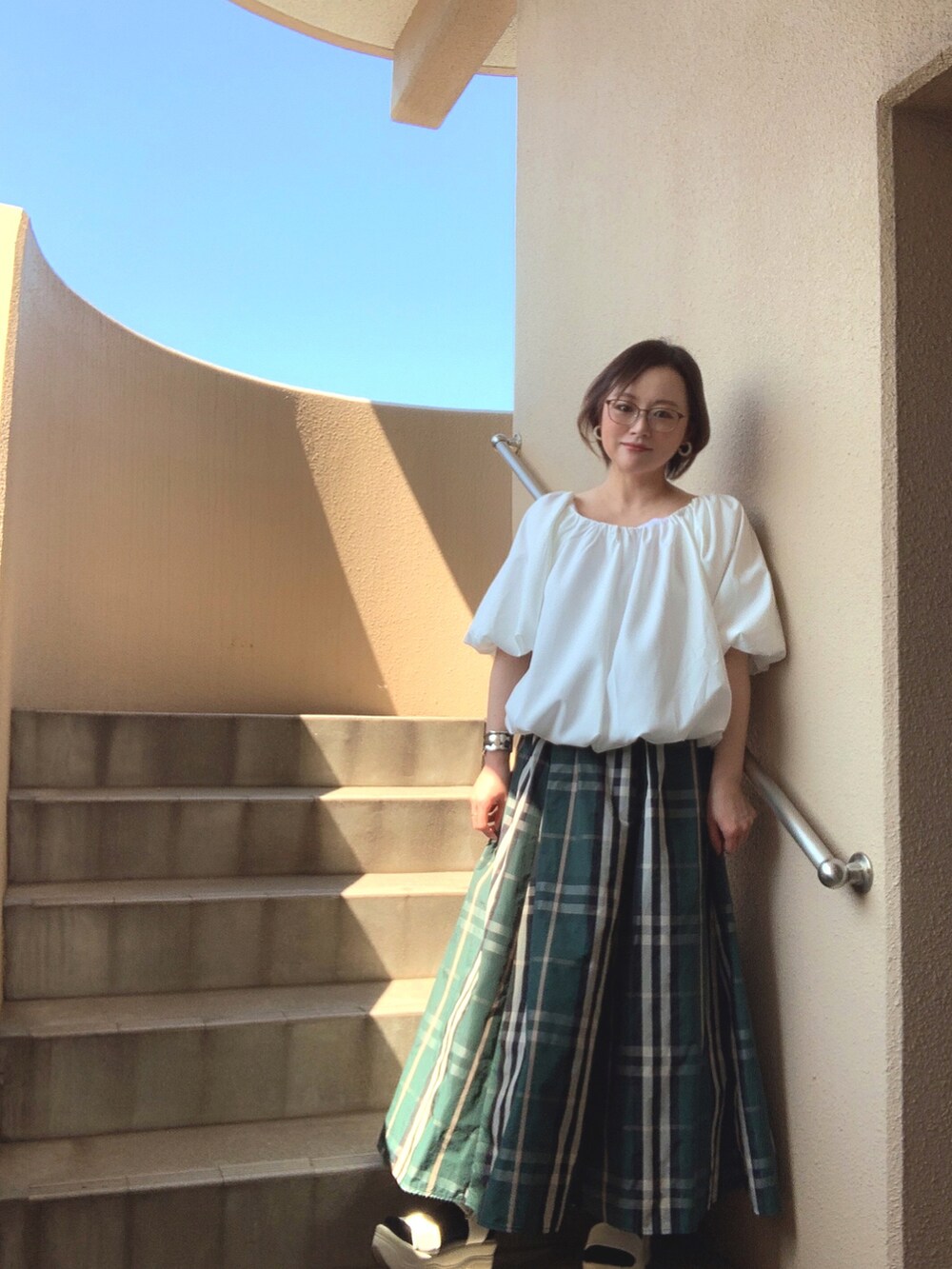 ホワイト系のシャツ/ブラウス、グリーン系のスカート、ホワイト系のサンダルを着用したレディースの夏コーディネートの3枚目の写真