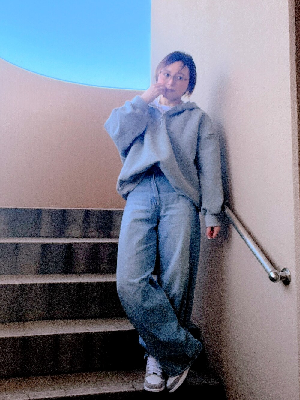 グレー系のセットアップ、ホワイト系のTシャツ/カットソー、ブルー系のデニムパンツを着用したレディースの冬コーディネートの2枚目の写真