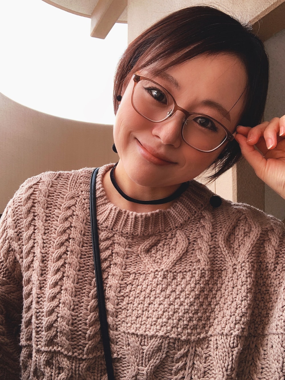 ブラウン系のニット/セーター、ブルー系のデニムパンツ、ブラック系のブーツを着用したレディースの冬コーディネートの3枚目の写真