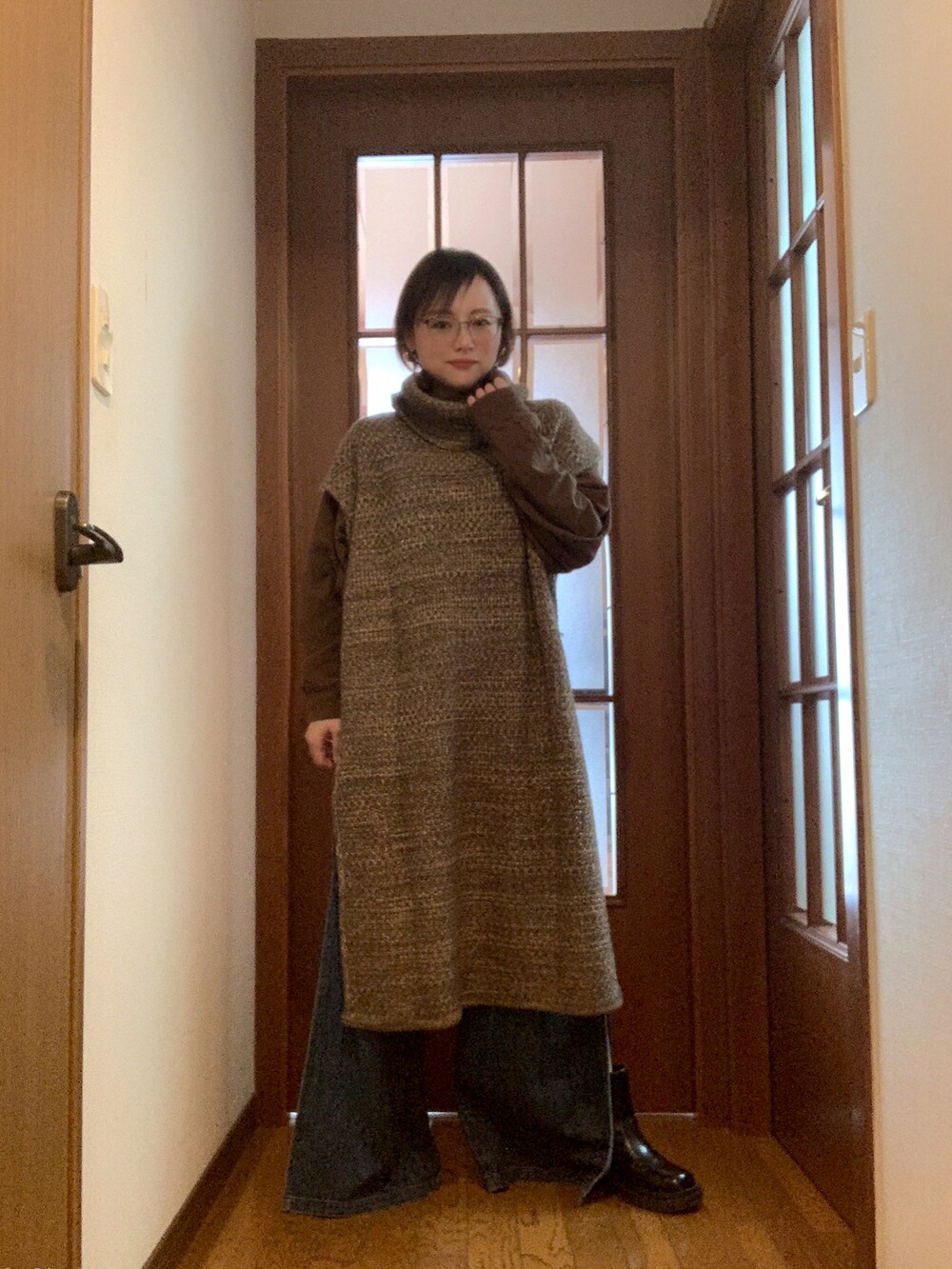 ブラック系のショルダーバッグ、グリーン系のニット/セーター、ブラウン系のTシャツ/カットソーを着用したレディースの冬コーディネートの2枚目の写真